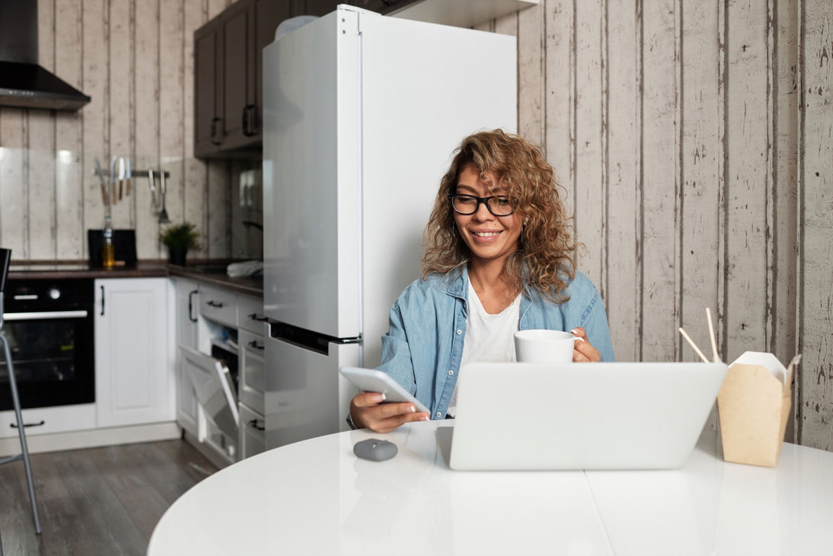 Woman working on a laptop at a kitchen table during a power outage